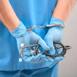 A doctor in blue scrubs holds a stethoscope, ready to examine a patient with professionalism and care.